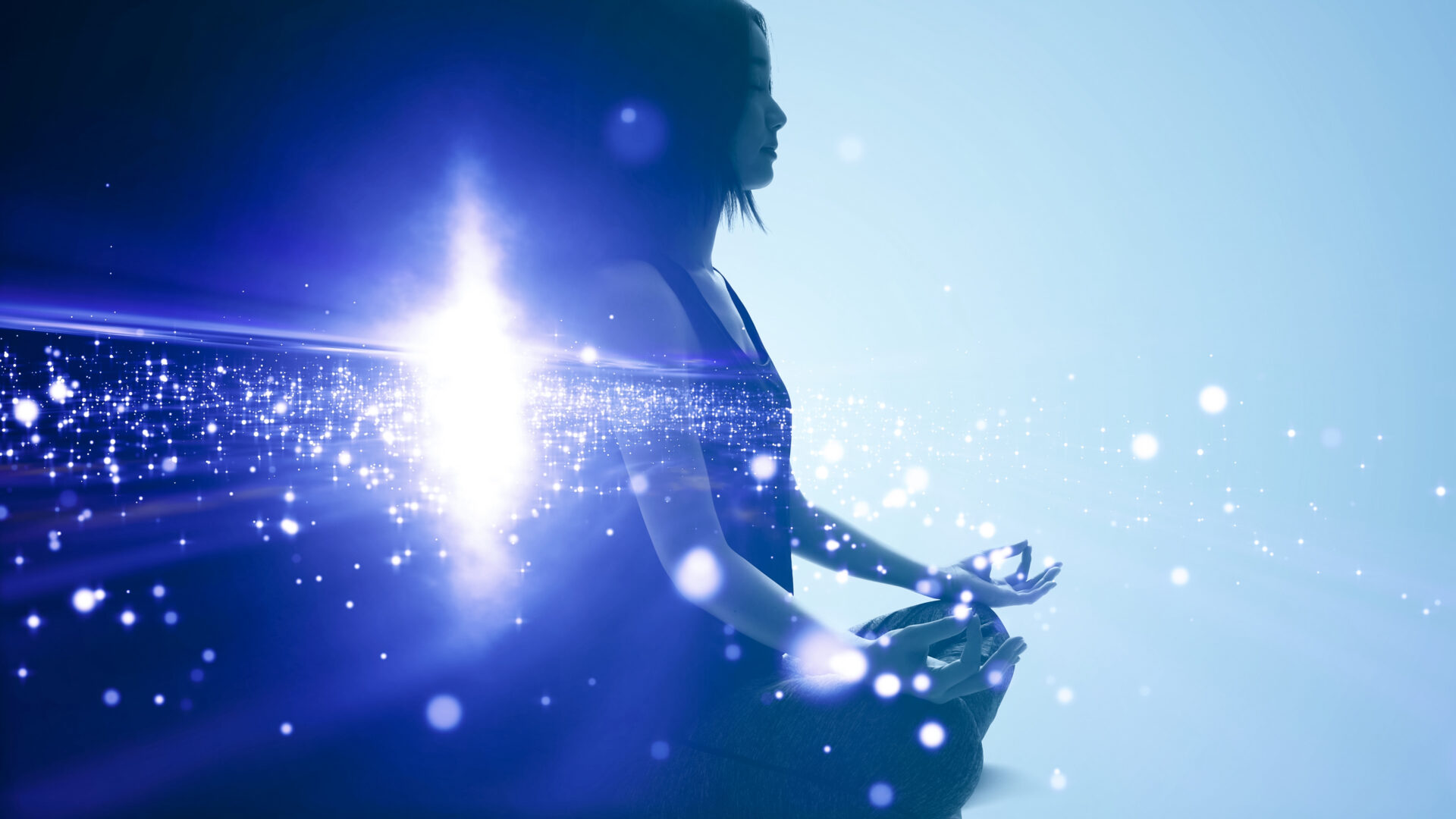 Person meditating with glowing light effects.